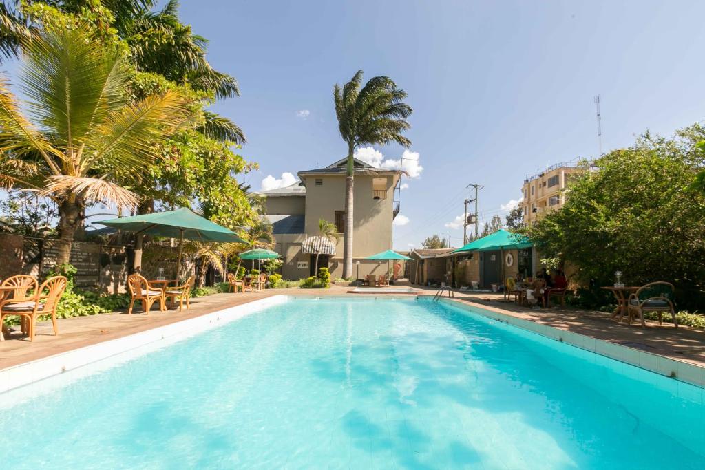 内罗毕法哈利花园酒店的一个带椅子和遮阳伞的大型游泳池