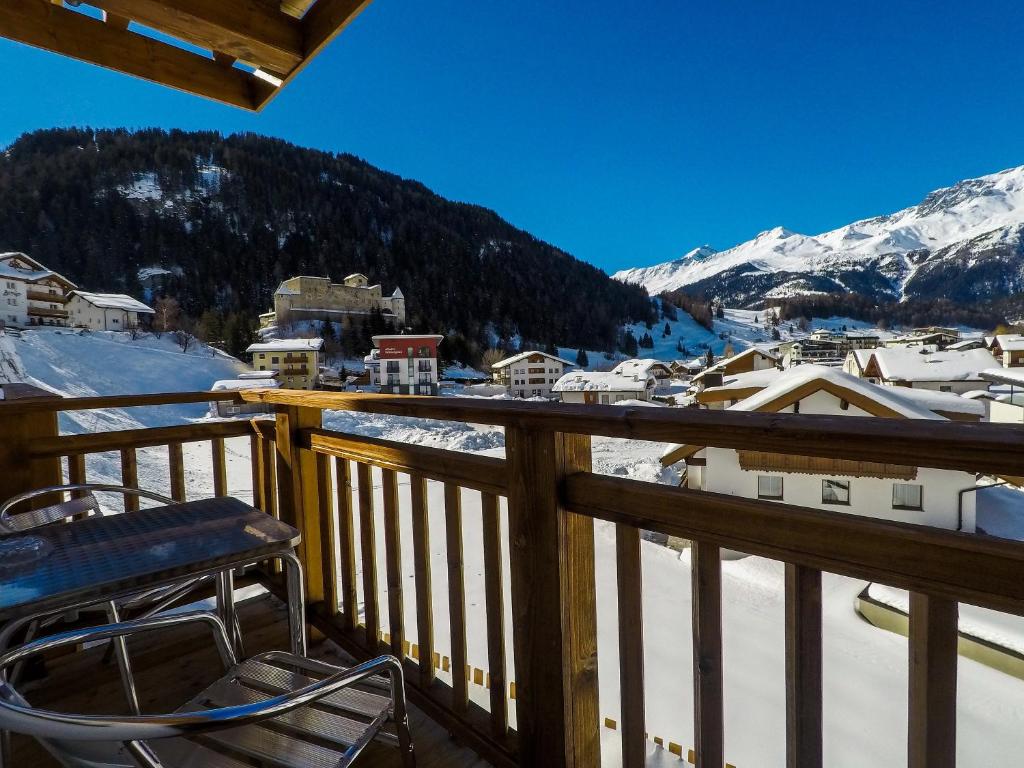 瑙德斯Collina Hotel Garni的阳台配有椅子,被雪覆盖的山脉