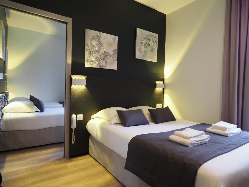 维希Hôtel Le Biarritz - Vichy的酒店客房,设有两张床和镜子