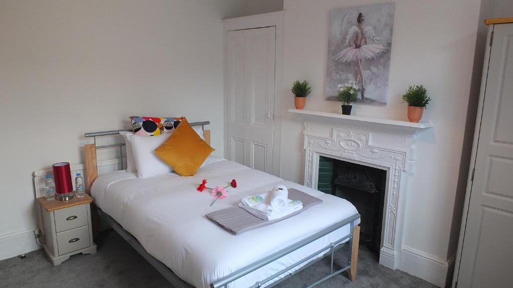 剑桥The Mill Suites - Tas Accommodations的卧室配有1张白色床和壁炉