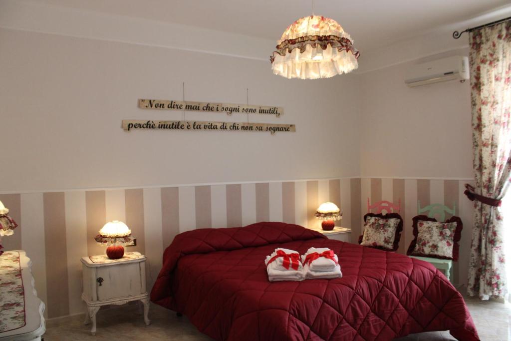 塔兰托Suite Liberty的一间卧室配有红色的床和2条毛巾