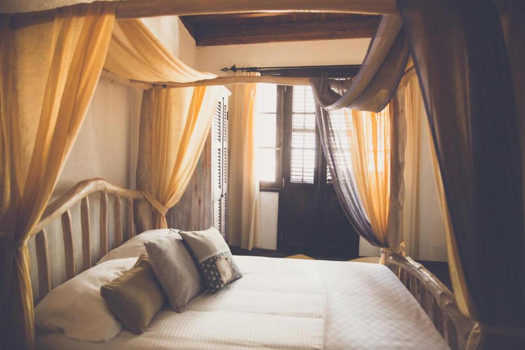 北尼科西亚The Iskemleci Guest House的一间卧室配有带窗帘的床和窗户