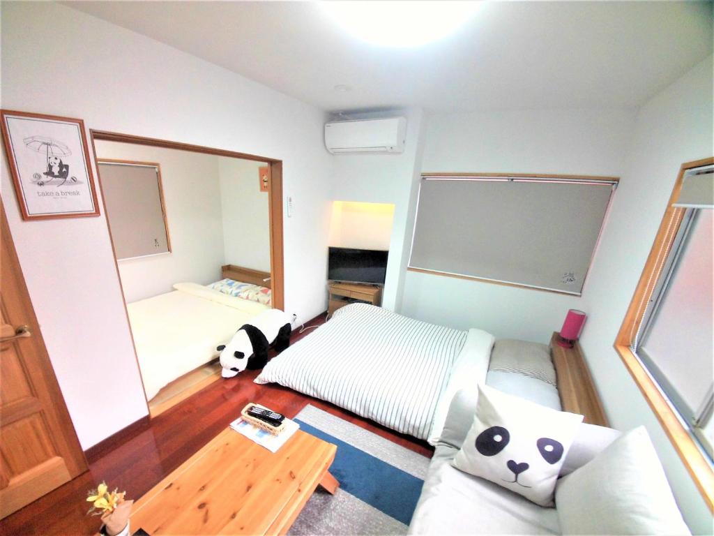 冈山冈山熊猫度假屋的一间卧室配有一张床和一面大镜子