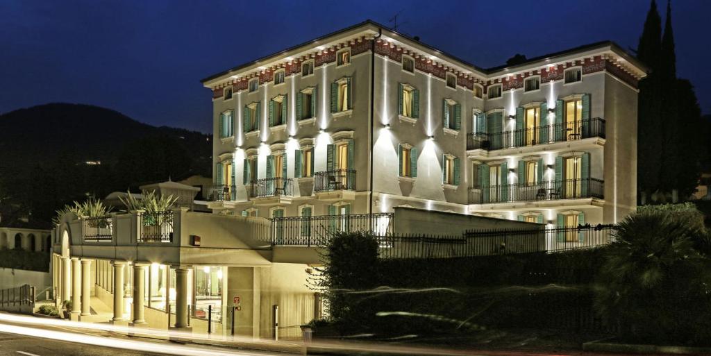加尔多内-里维耶拉Mefuta Hotel的一座白色的大建筑,晚上有灯