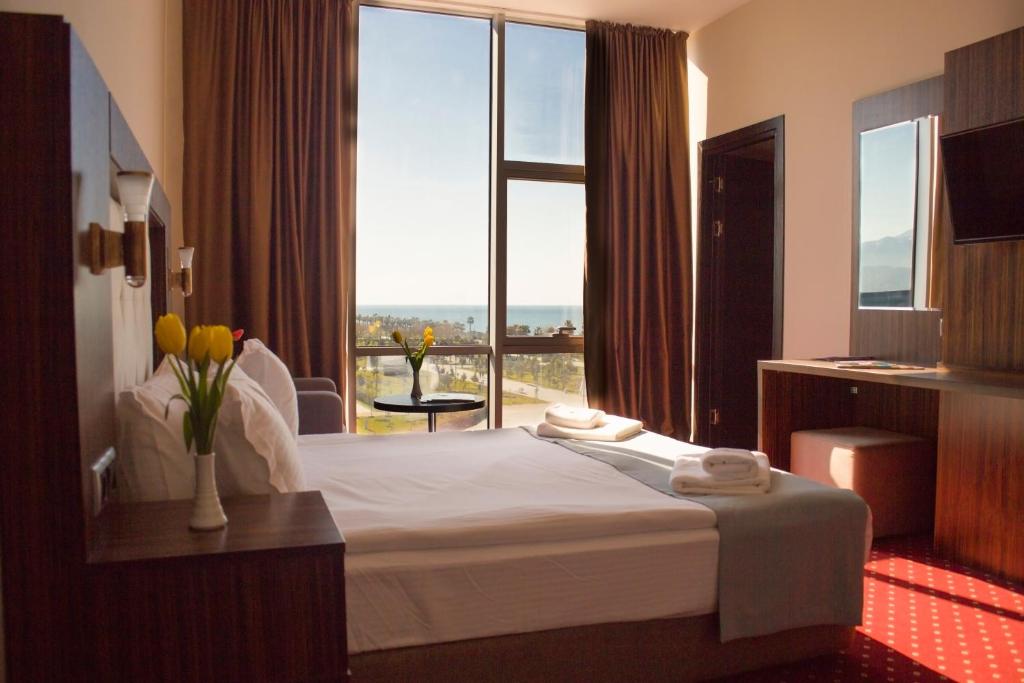 巴统Legend Business Hotel Batumi的酒店客房设有一张床和一个大窗户