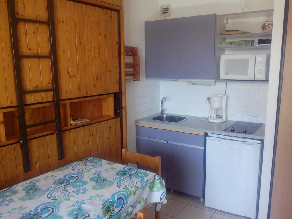 布科·莱斯白老城Studio Poumatan的厨房配有蓝色橱柜、桌子和水槽
