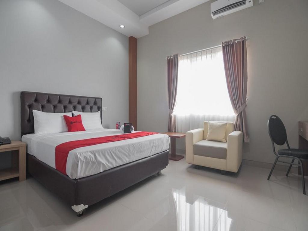 沙马林达RedDoorz near Islamic Center Samarinda的卧室配有床、椅子和窗户。