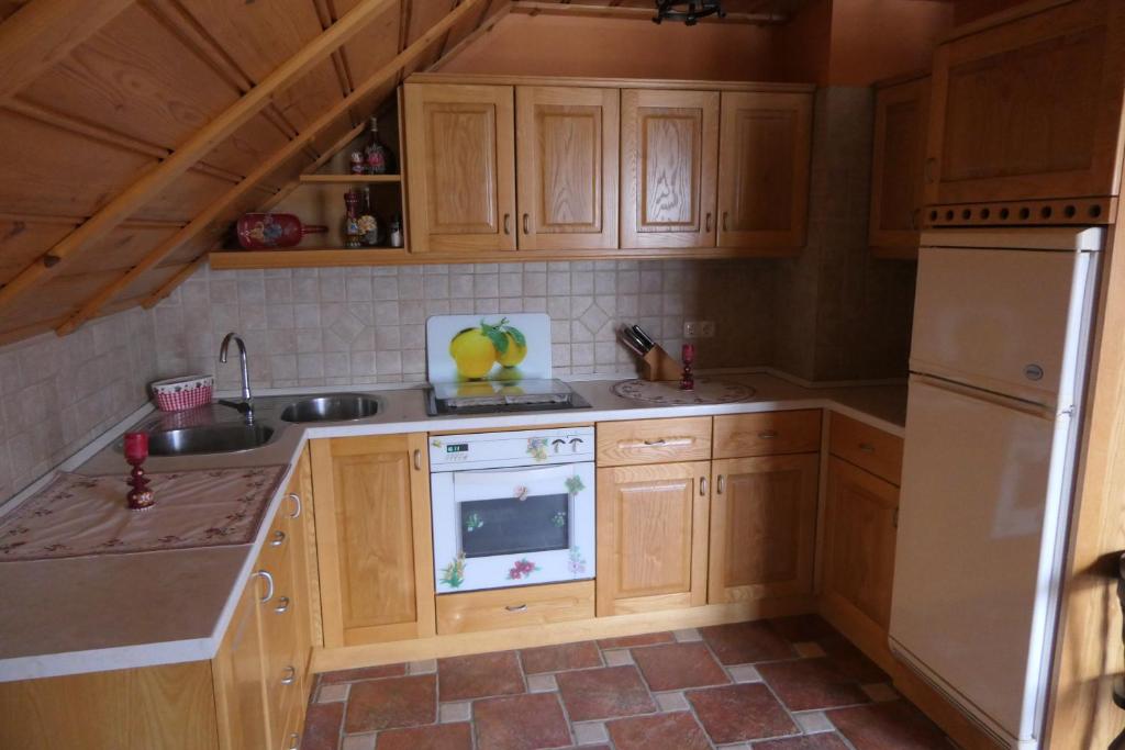 布莱德Apartments and rooms Brunko的厨房配有木制橱柜和白色冰箱。
