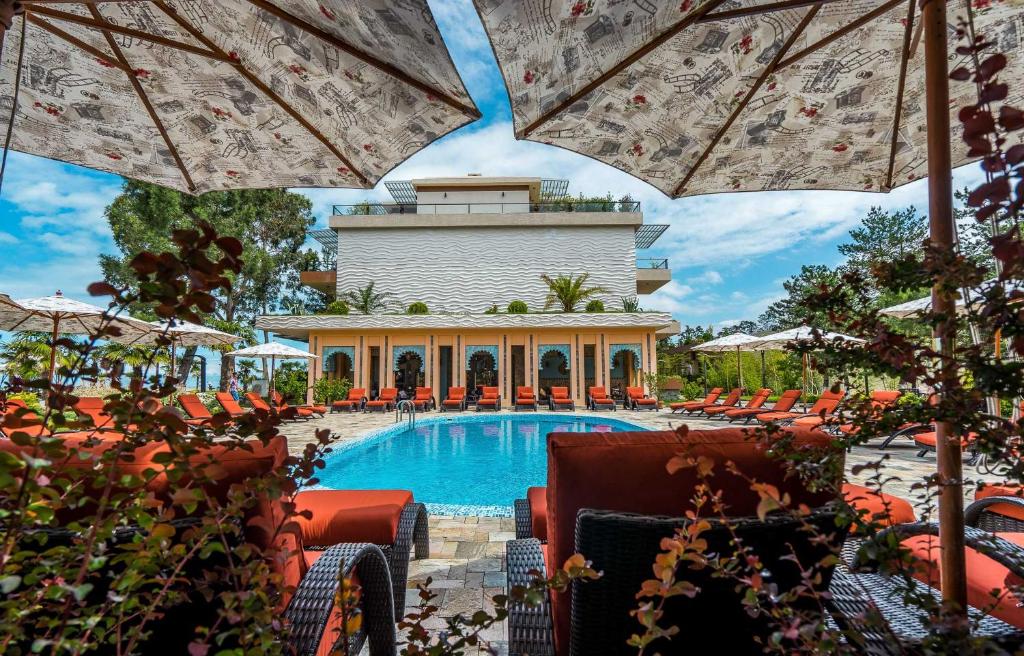 查克维Luxury Oasis Apartment的度假村的游泳池,配有椅子和遮阳伞