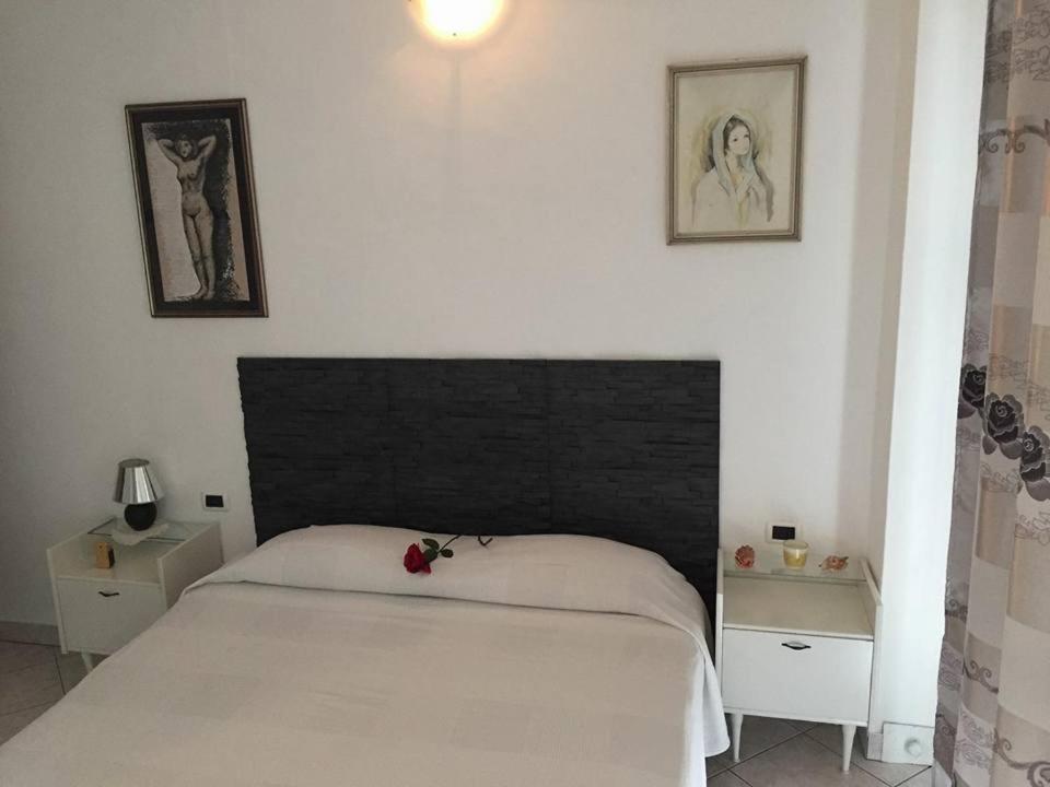 Goito卡萨爱多旅馆的一间卧室配有一张白色的床和黑色床头板