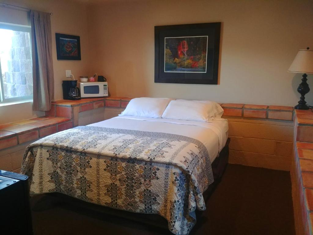 佩吉Lake Powell Motel &amp; Apartments的一间卧室配有一张床和一台微波炉