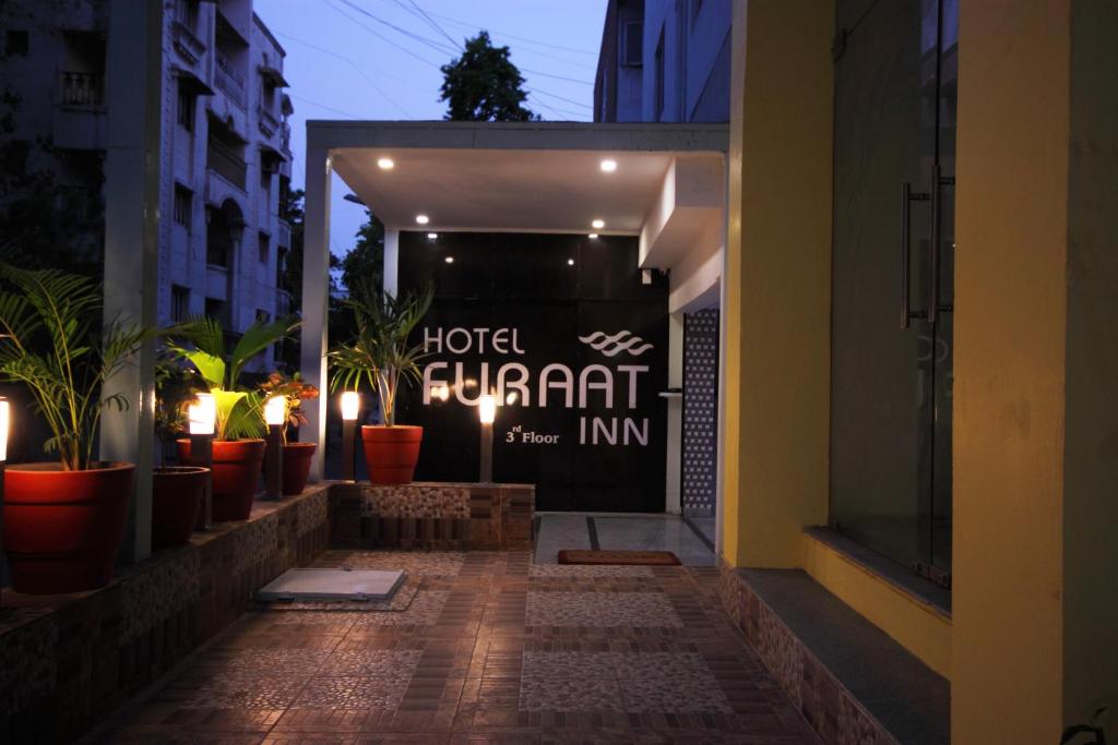 艾哈迈达巴德Hotel Furaat Inn的建筑中带有盆栽植物的酒店入口