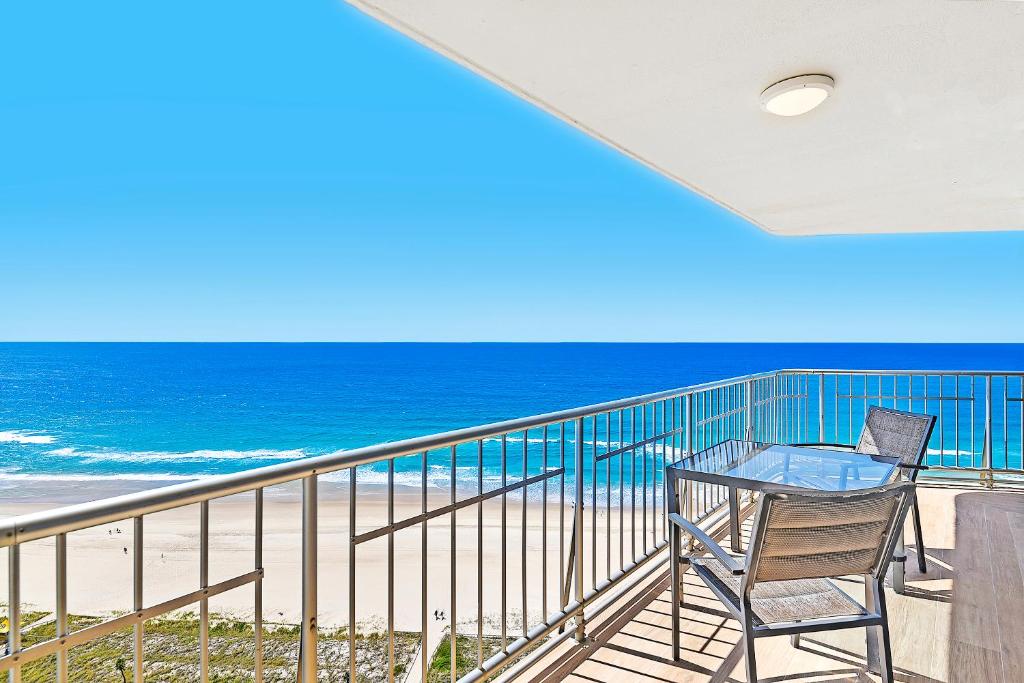 黄金海岸塔利斯曼公寓的一个带桌椅和海滩的阳台