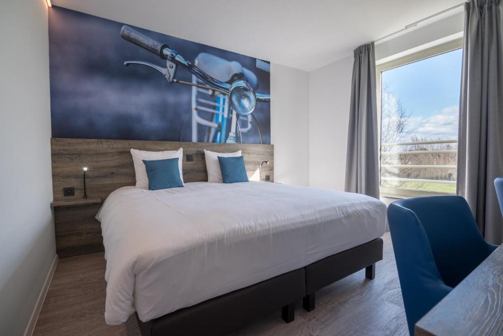 布鲁日布鲁日维罗特尔酒店的卧室配有一张床,墙上挂有绘画作品