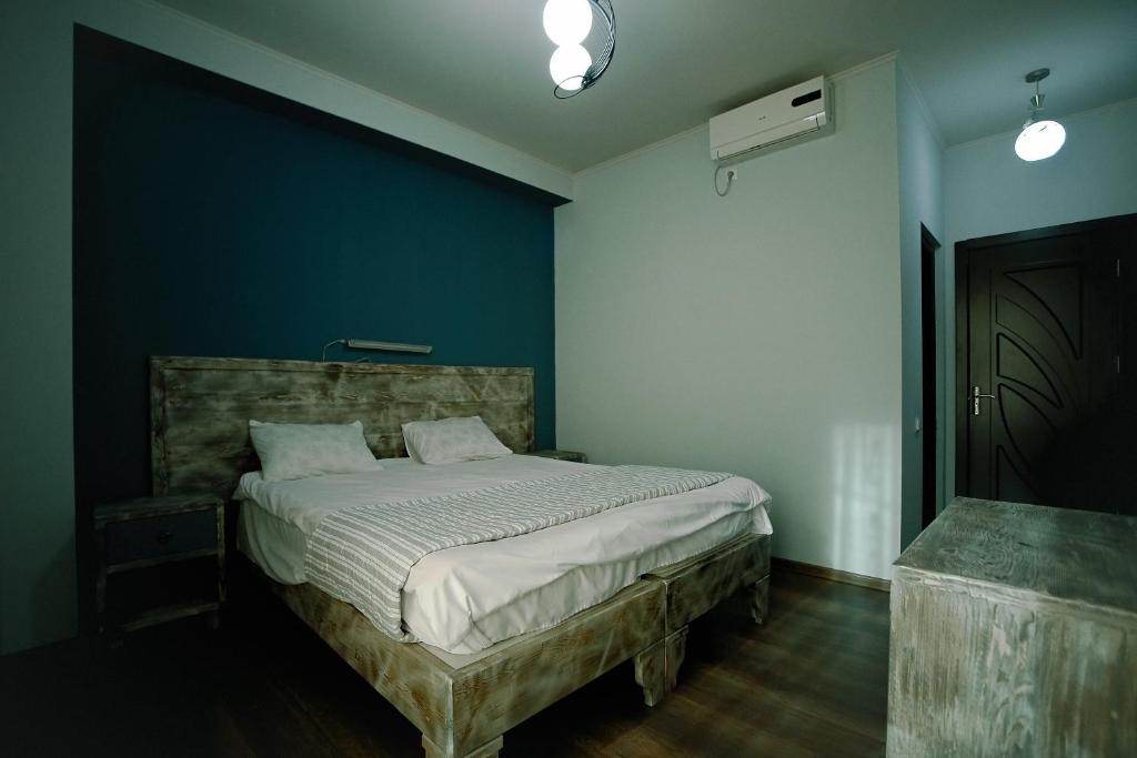 库塔伊西Hotel Kutaisi Globus的一间卧室配有一张蓝色墙壁的床