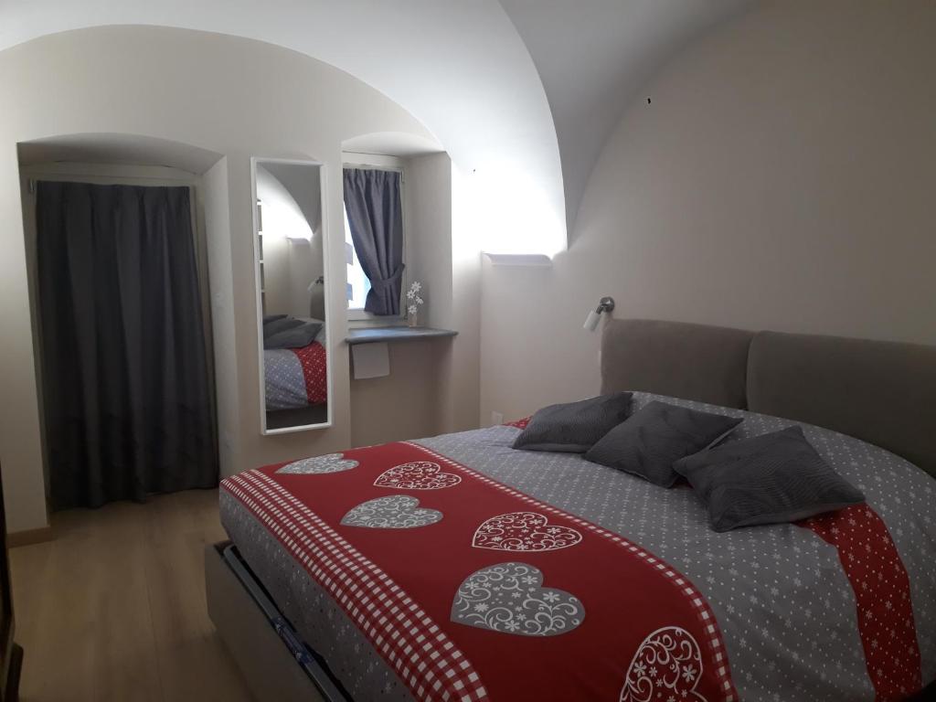 奥斯塔Aosta Romana case vacanza的一间卧室配有一张带红白毯子的床