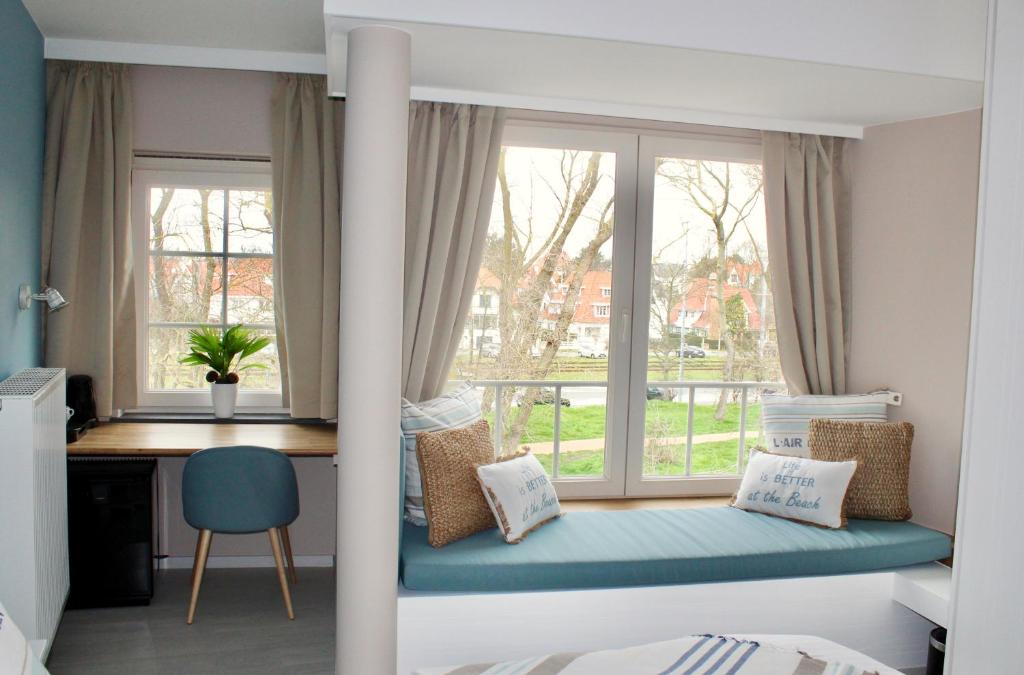 德哈恩维尔德别墅住宿加早餐旅馆的一间卧室配有一张床、一张书桌和一个窗户。