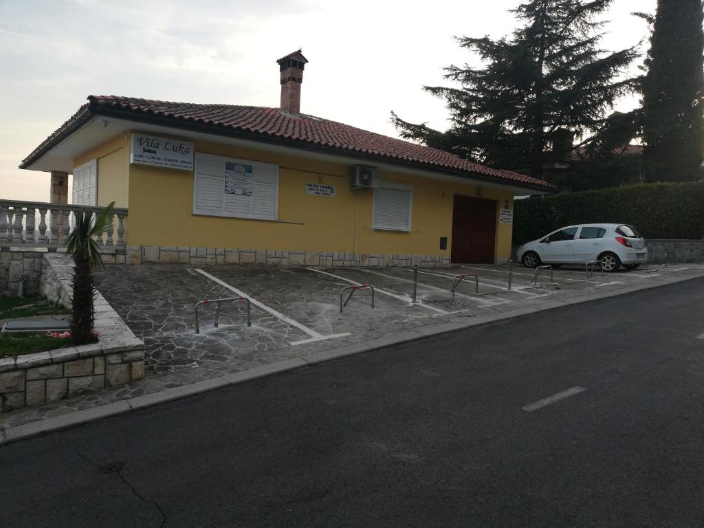 波尔托罗Guest House Vila Luka的一座黄色的房子,前面有一辆汽车