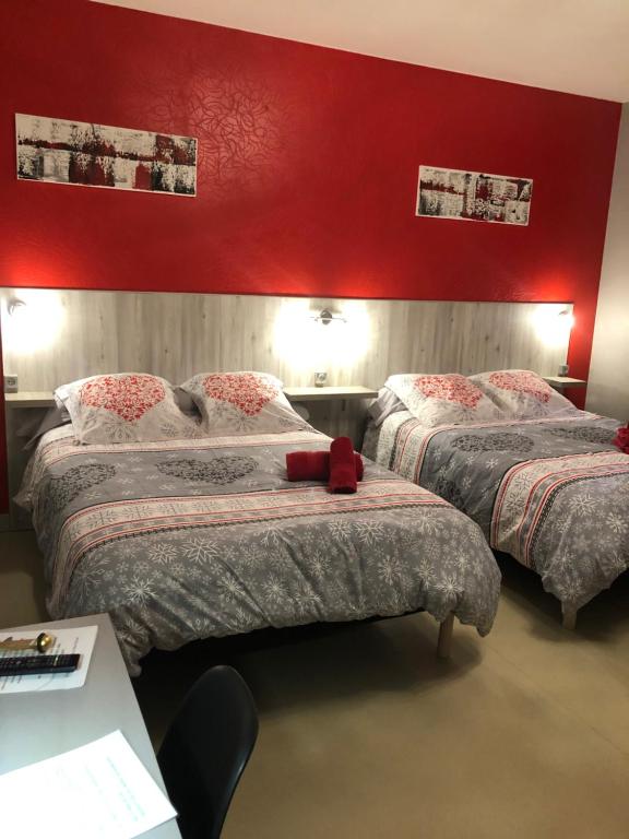 洛特河畔的维伦纽夫德斯公寓酒店的一间卧室设有两张床和红色的墙壁