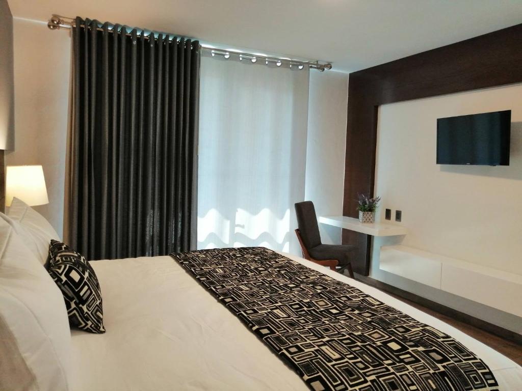 JamayHotel Corral Grande的酒店的客房 - 带一张床、椅子和窗户