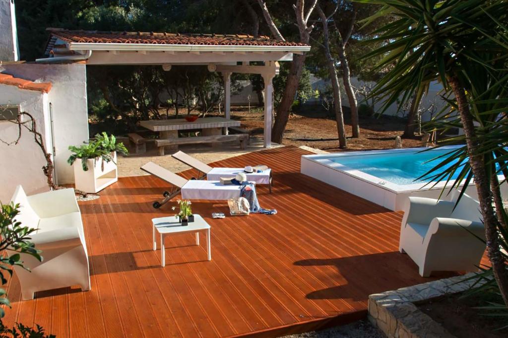 加利波利Villa Conca D'oro的庭院设有游泳池、椅子和桌子。