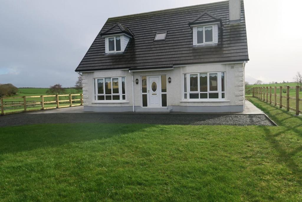 梅奥INGLEWOOD - Ballina - Crossmolina - County Mayo - Sleeps 8 - Sister property to Thistledown的一间白色的房子,有黑色的屋顶和院子