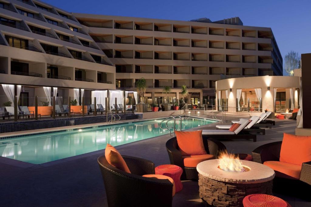 棕榈泉凯悦棕榈泉酒店的一座带游泳池和椅子的酒店和一座建筑