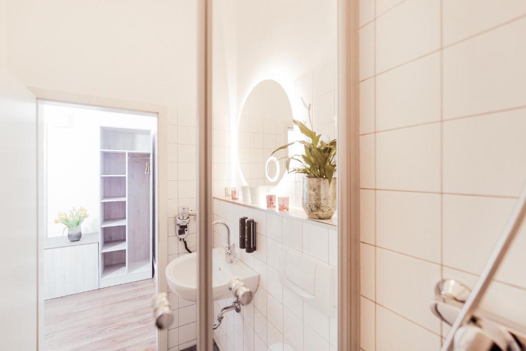海德堡丹纳酒店的白色的浴室设有水槽和镜子