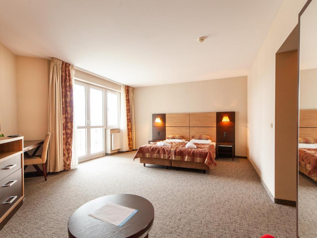 科沃布热格Apartament hotelowy Delux w Kołobrzeg Przy pobycie 7 nocy rabat 10 procent Przy pobycie 28 dni 30 procent rabatu的酒店客房设有两张床和一张桌子。