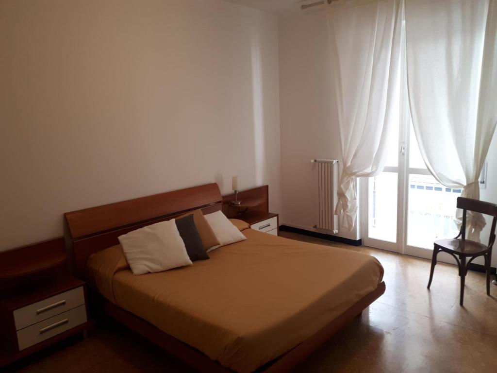阿尔本加Appartamento Quadrilocale的一间卧室设有一张床和一个大窗户