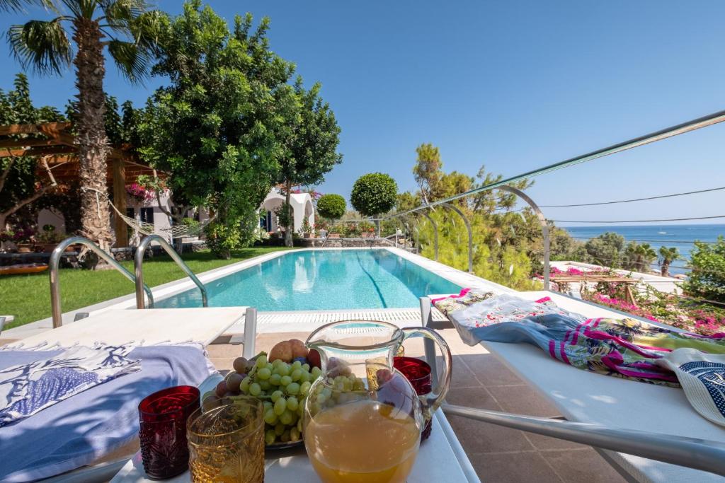 卡马利Santorini Mystique Garden Villa的游泳池旁的一张桌子和一碗水果