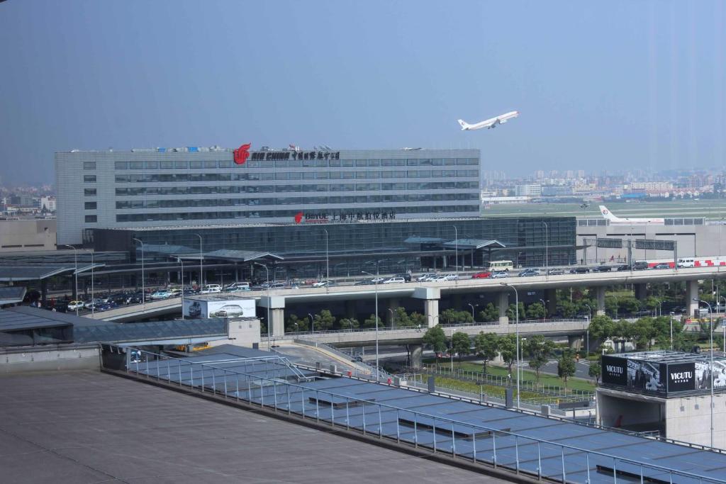 上海上海中航泊悦酒店（中国国际航空公司）的一座机场,有一座大建筑,一架飞机飞过机场