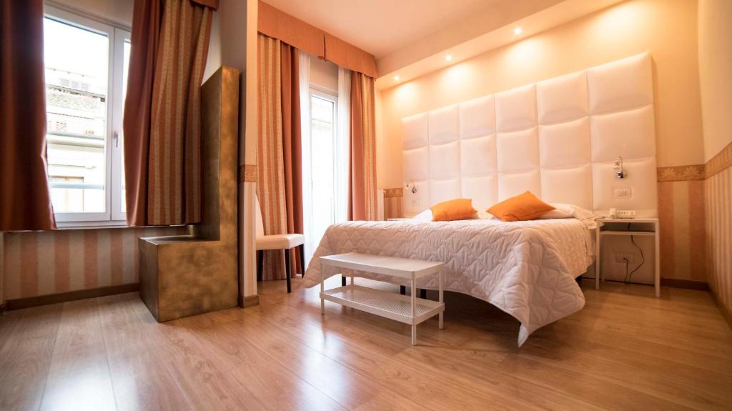佛罗伦萨简酒店的一间卧室配有一张床、一张桌子和一个窗户。