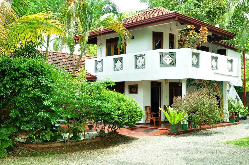 阿鲁特伽马Solal Villa的一座种有树木和植物的白色房子