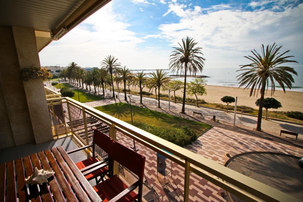 坎布里尔斯GOLF ST JORDI 2 Planet Costa Dorada的阳台设有长凳,享有海滩美景。