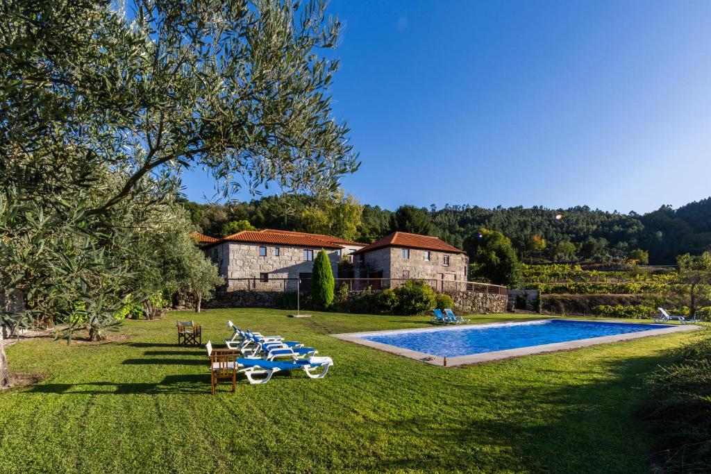阿马兰特Quinta da Pousadela - Agroturismo的一个带椅子的游泳池和房子的庭院