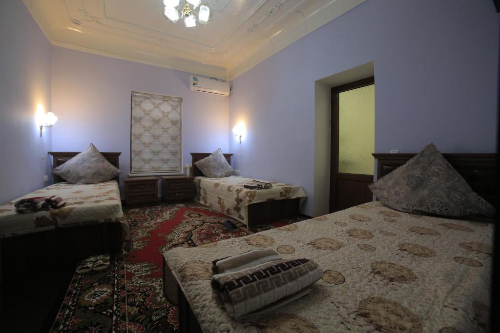 布哈拉Alliance hotel bukhara的酒店客房设有两张床和窗户。