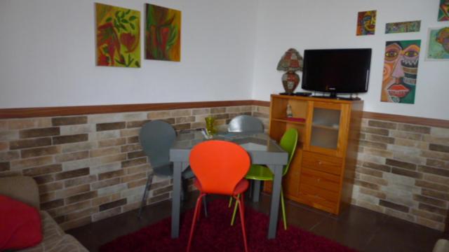 塔维拉A Casa da Maria的配有桌子和两把椅子以及电视的房间