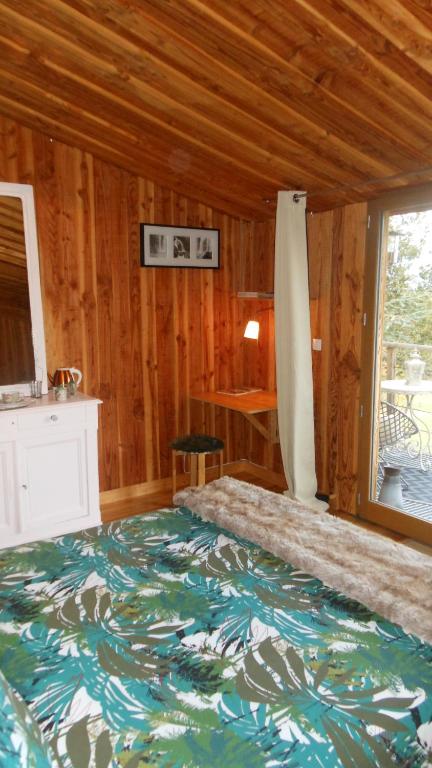 多尔戈利斯Domaine de Sault的木制客房内的一间卧室配有一张大床