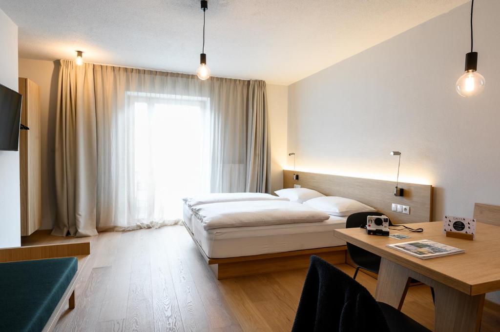 马莱斯韦诺斯塔卡尔瓦住宿加早餐公寓的配有一张床、一张书桌和一扇窗户的酒店客房