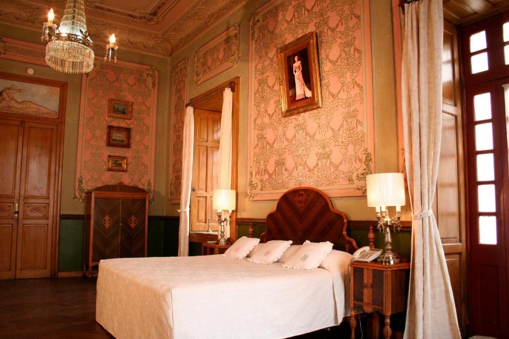 普埃布拉卡萨德拉帕尔马精品酒店的一间卧室配有一张床和一个吊灯