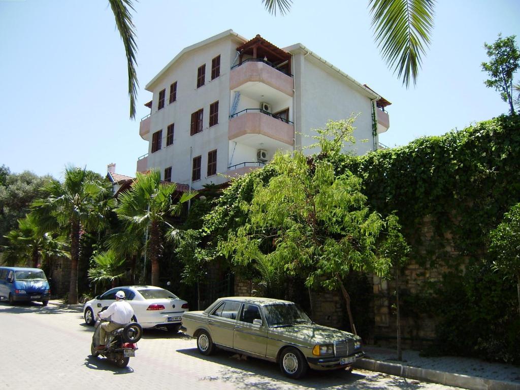 达特恰Datca Hotel Antik Apart的停在大楼旁边的停车场的汽车