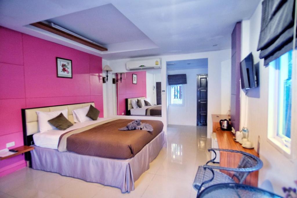 拉迈拉迈度假村的卧室配有一张带粉红色墙壁的大床