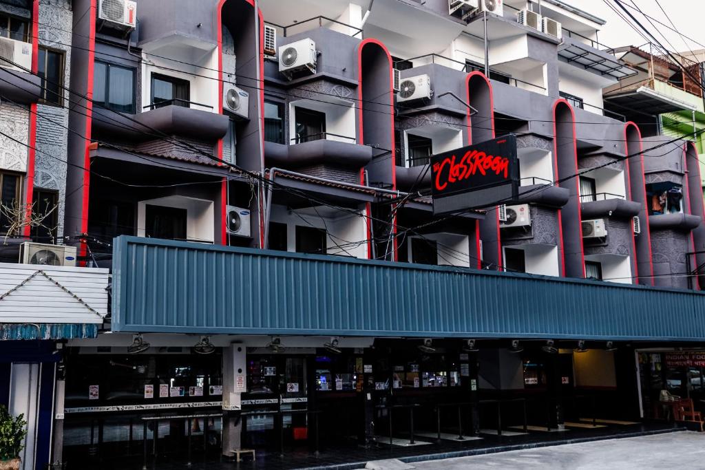 芭堤雅市中心格拉斯鲁姆酒店的带有读取 ⁇ 红符号的建筑物