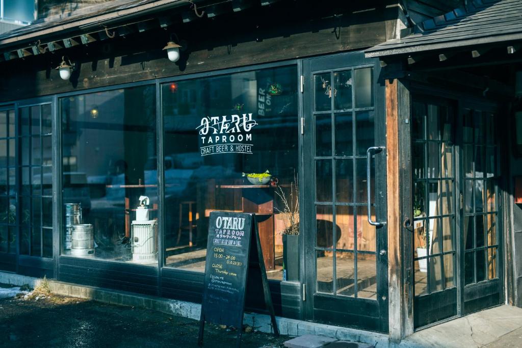 小樽Otaru Tap Room & Hostel的前面有标志的商店窗口