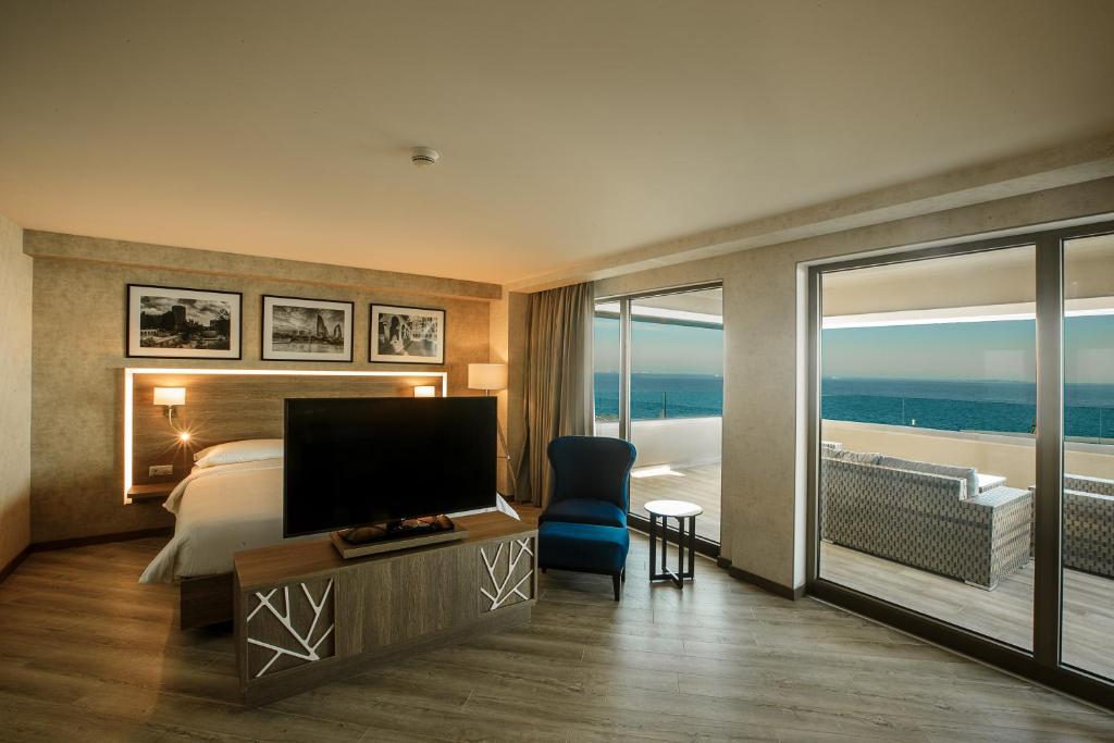 巴库Radisson Hotel Baku的酒店客房设有床、电视和阳台。