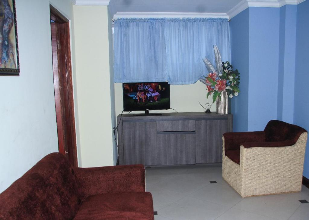 阿克拉Ridge Over Suite的客厅配有两把椅子和电视