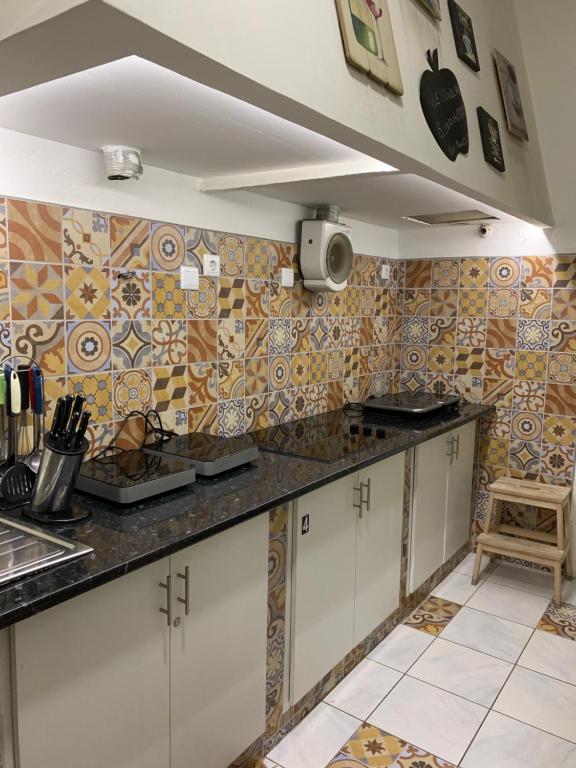 波瓦-迪瓦尔津Big House的厨房配有白色橱柜,墙上铺有瓷砖。