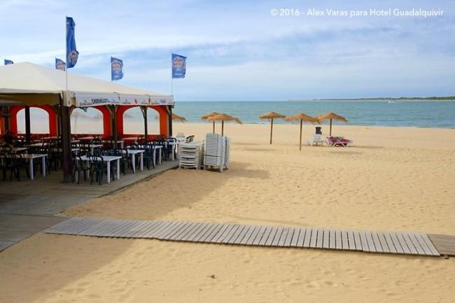 桑卢卡尔-德巴拉梅达Playa de Las Piletas的海滩上带桌椅和遮阳伞的海滩