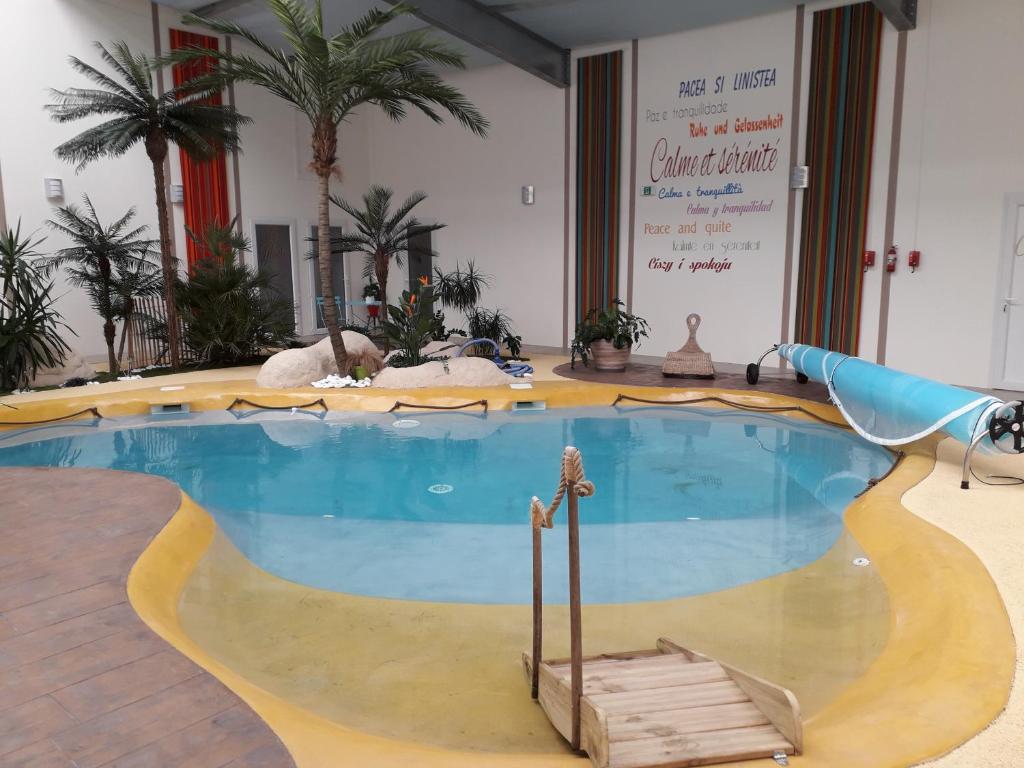 博瓦Résidence Beauvoir le Mont-Saint-Michel (9 gîtes de 2 à 5 personnes)的棕榈树客房内的大型游泳池